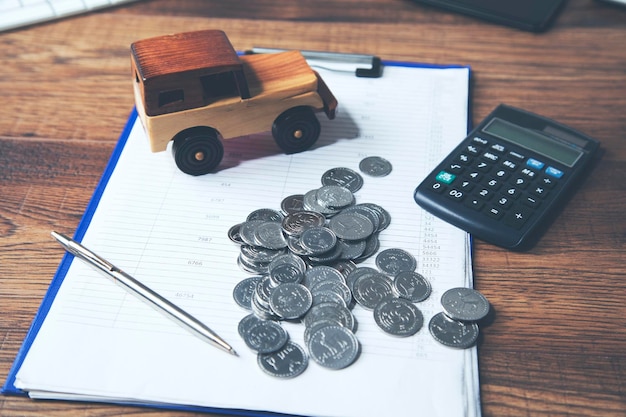 Car with calculator and money on wood table