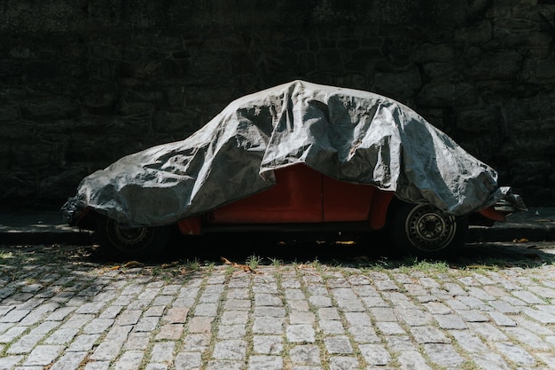 Car with cover on cobblestone street