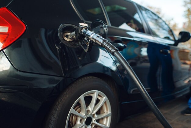 Car with gun in tank closeup, fueling on gas station, fuel refill, nobody. Petrol, gasoline or diesel refuel service, petroleum refueling