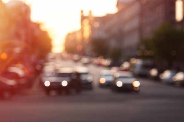 Automobile con le luci alla sera sulla strada di città