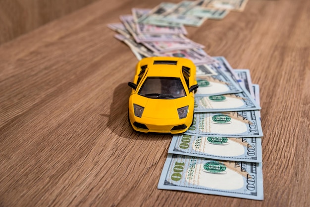 Car with money way on wooden background