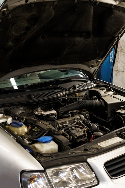 Car with a nopen hood in the automobile repair shop