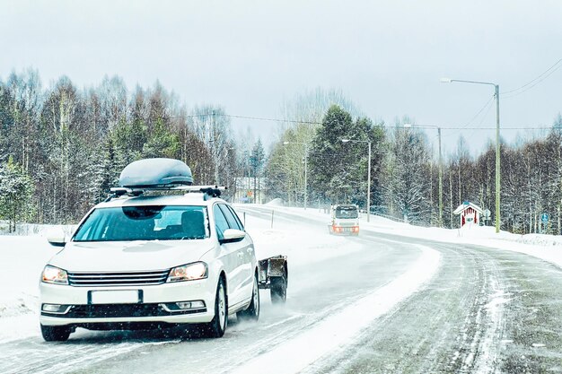 Car with roof luggage rack  in the road in Finland, winter Rovaniemi, Lapland