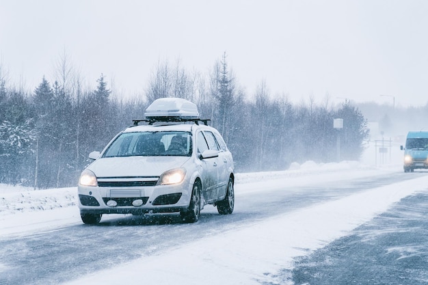 Автомобиль с багажником на зимней заснеженной дороге в Рованиеми в Лапландии, Финляндия