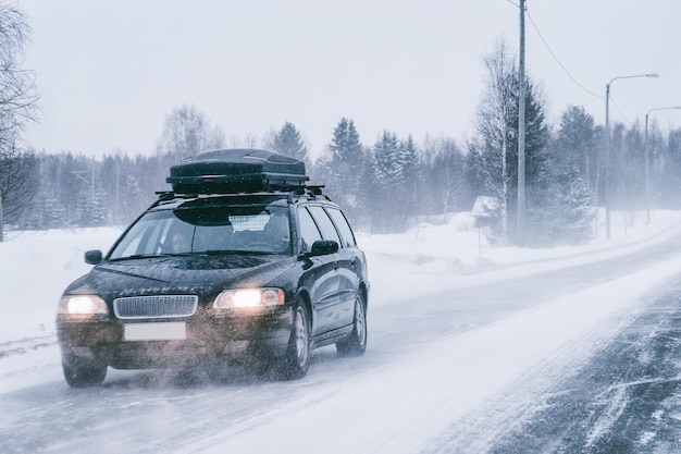 Car with roof rack at the winter snowy road in Rovaniemi in Lapland, Finland