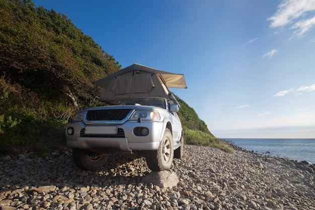 Car with roof tent at the sea shore