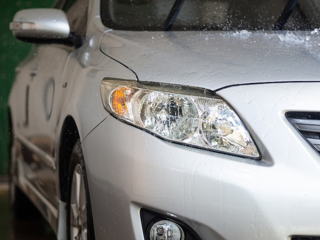 The car with water on the body in car care shop.