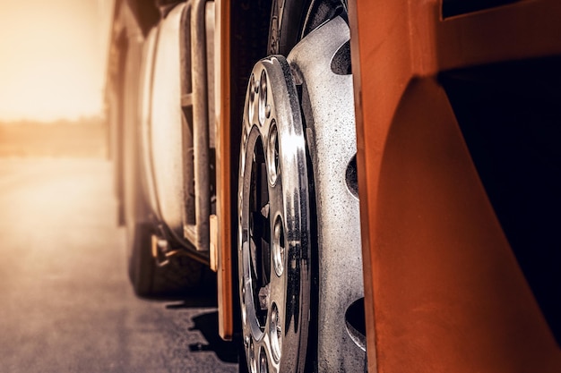 A car with a white rim is parked on the side of the road.