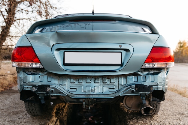 Un'auto senza paraurti il tubo di scarico è visibile il cofano del bagagliaio è ammaccato auto dopo l'incidente