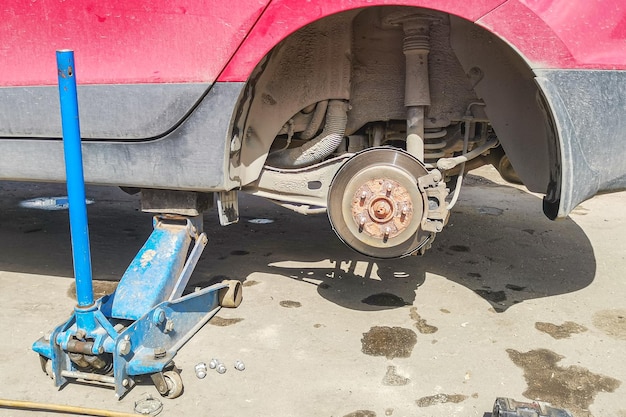 Car without wheel lift up by hydraulic waiting for tire replacement