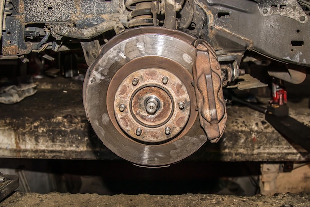 Car without wheels closeup of car disc brake for repair