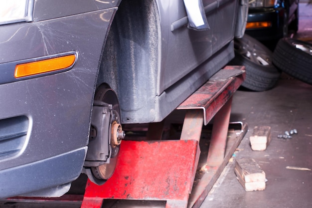 写真 修理中の自動車修理店で車輪のない車。