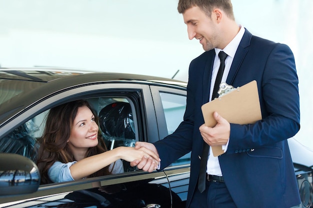 Gente di affari delle donne dell'automobile che parla sorridente all'aperto