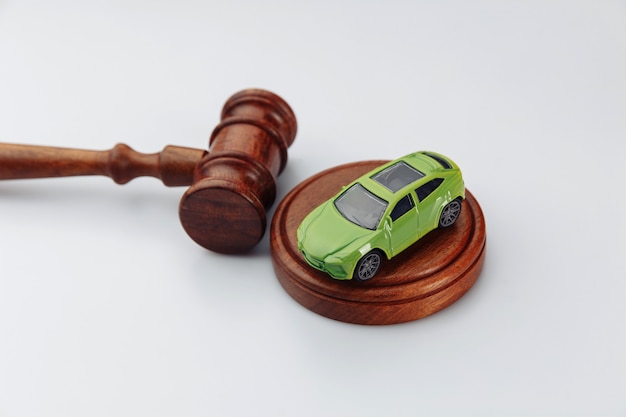 Car and wooden judge gavel on a white.