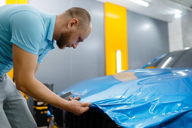 Car wrapper puts protective foil or film on hood