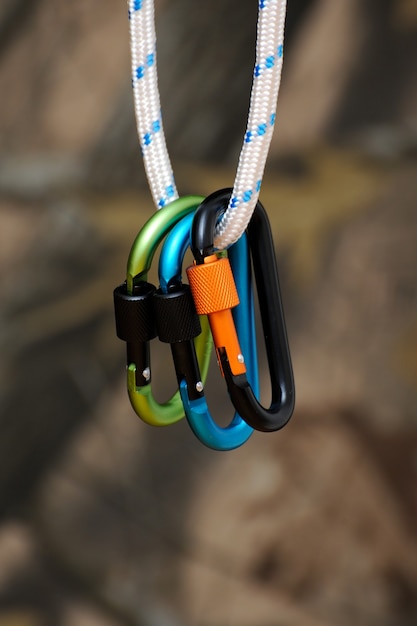 Carabiner for climbing close-up on blurred nature background.