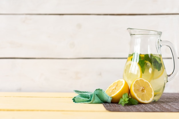 Carafe of lemonade and mint on a white background.