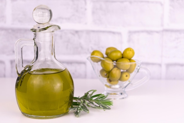 Caraffa di olio d'oliva su un tavolo su sfondo bianco