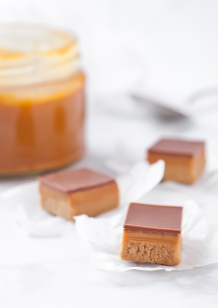 Caramel and biscuit shortcake bites dessert on marble board with jar of salted caramel