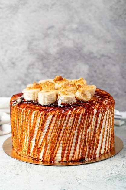 Caramel cake on a stone background Fruit and caramel birthday cake close up