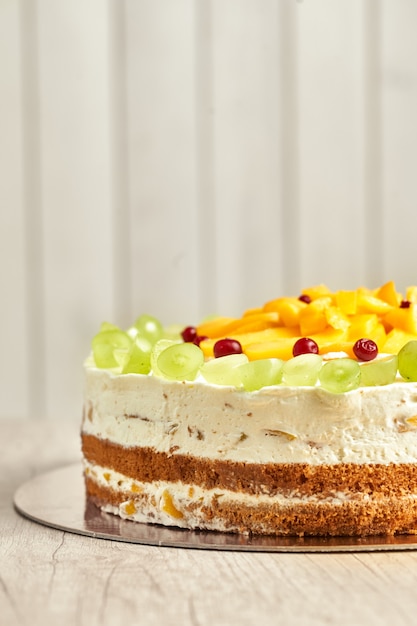 Caramel cake with fruits. Wooden background