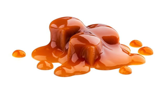 Photo caramel candies and caramel sauce isolated on white background
