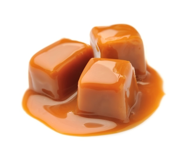 Photo caramel candies and caramel topping isolated.