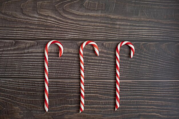 Lecca-lecca caramelle caramelle natalizie su fondo di legno scuro spase per le vacanze invernali di concetto di testo