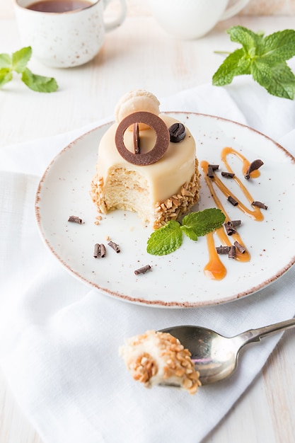 Карамельный кофейный торт в глазури с орехами на тарелке на белом фоне