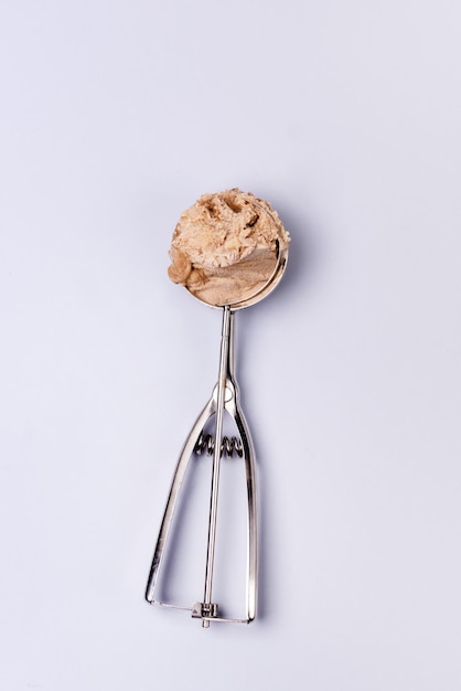 Photo caramel ice cream in ice cream scoop tasty ice cream vertical top view