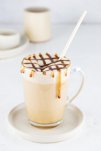 Caramel latte macchiato met kokosmelk in een glazen mok.