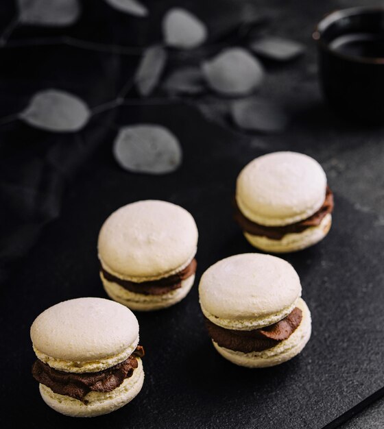 Caramel macarons with chocolate filling on black stone