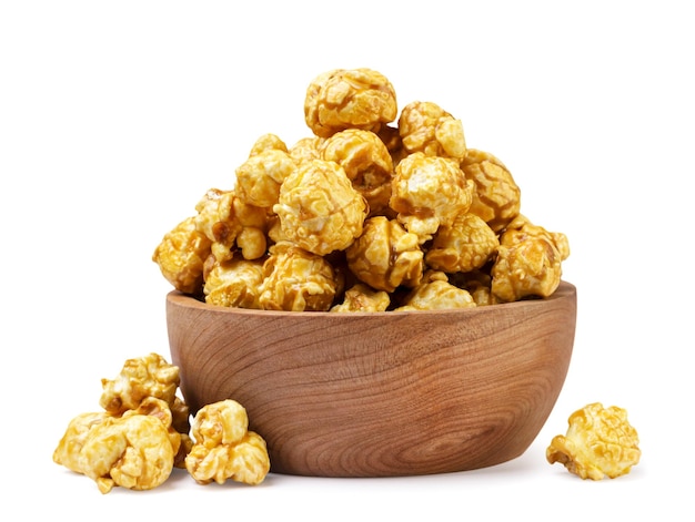 Foto caramel popcorn in een houten bord en verspreid op een witte achtergrond geïsoleerd