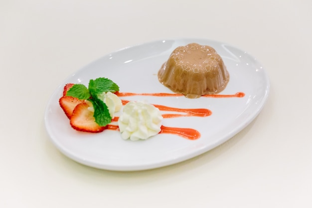 Caramel Pudding served with strawbery sauce.