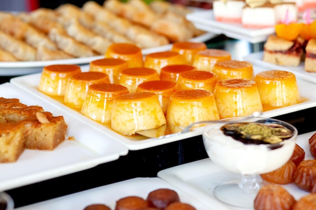 카라멜 바닐라 플란 터키 호텔의 디저트 테이블 뷔페에 다양한 케이크와 과자