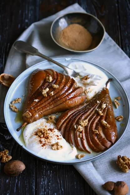 Caramelized pear with nuts and buttercream on a plate Healthy dessert