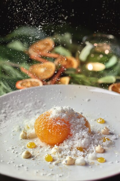 Caramelized tangerine with coconut flakes on background with christmas decorations