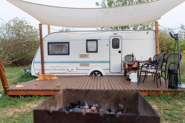 caravan or camper trailer with wooden deck at countryside glamping site outdoor camping