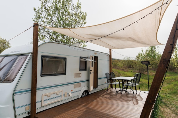caravan or camper trailer with wooden deck at countryside glamping site outdoor camping