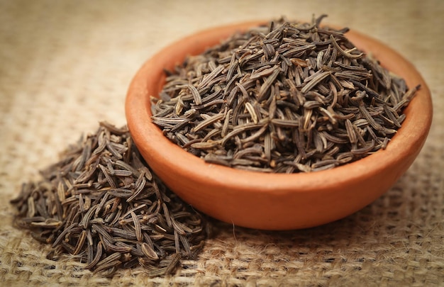 Caraway seeds in a bowl on jute