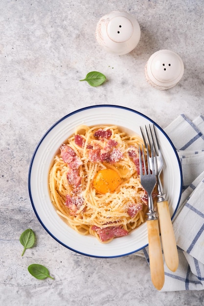 Carbonara pasta Spaghetti met pancetta ei Parmezaanse kaas en roomsaus op oude grijze betonnen tafel achtergrond Traditionele Italiaanse keuken en schotel Pasta alla carbonara Bovenaanzicht