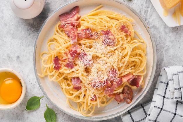 Carbonara pasta Spaghetti with pancetta egg parmesan cheese and cream sauce on old gray concrete table background Traditional italian cuisine and dish Pasta alla carbonara Top view