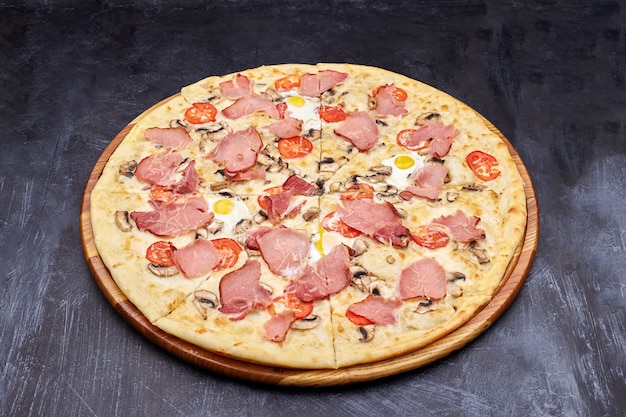 Carbonara pizza with bacon and egg on beautiful grey table.