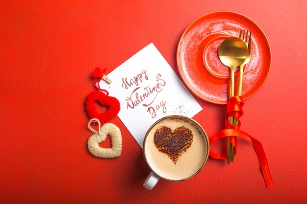 Card message with Happy Valentines day, golden cutlery, coffee and heart toys