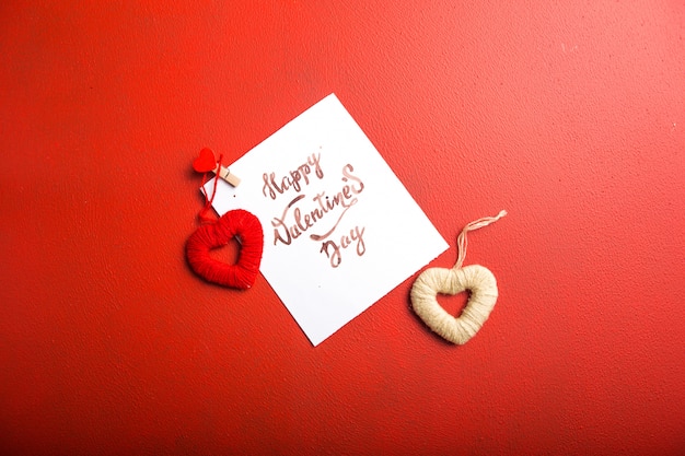 Card message with Happy Valentines day and heart toy on red table