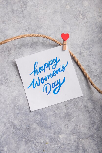 Card message with Happy Women day on grey table