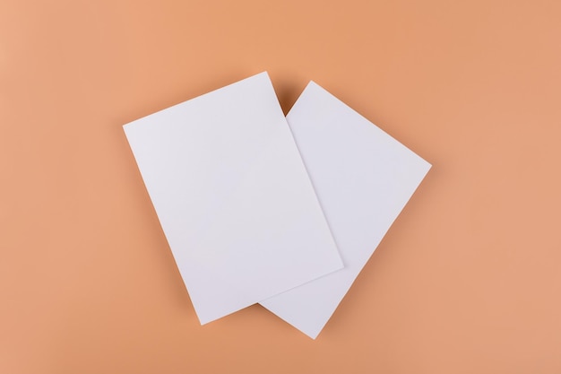 Mockup di carta di due inviti di carta 5x7 bianchi vuoti su sfondo nudo beige o terracotta design minimalista semplice e funzionale con colori neutri