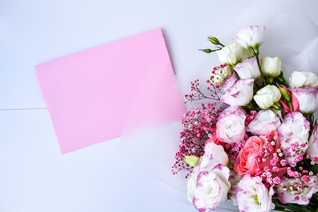 Mockup di carta con bouquet delicato. sfondo floreale. vista dall'alto appartamento laico holiday card 8 marzo, buon san valentino, concetto di festa della mamma. copia spazio per il testo. biglietto di auguri vacanza