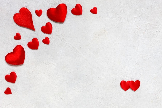 Card to St. Valentine's day with a frame of red textile hearts on a white background.