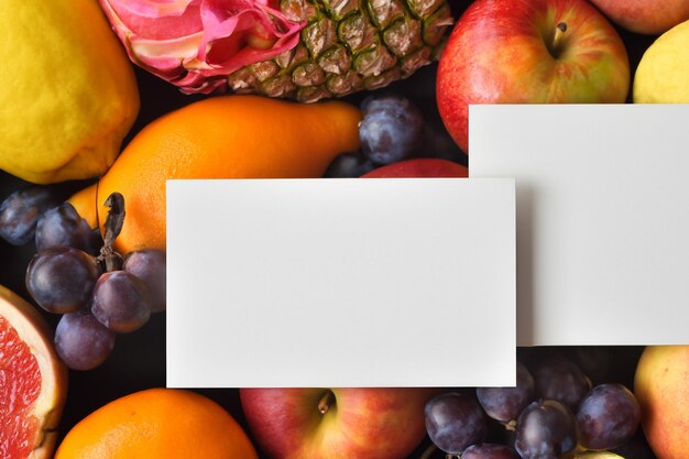 Foto mockup di carta e carta bianca armonizzati con frutta fresca creando una sinfonia visiva